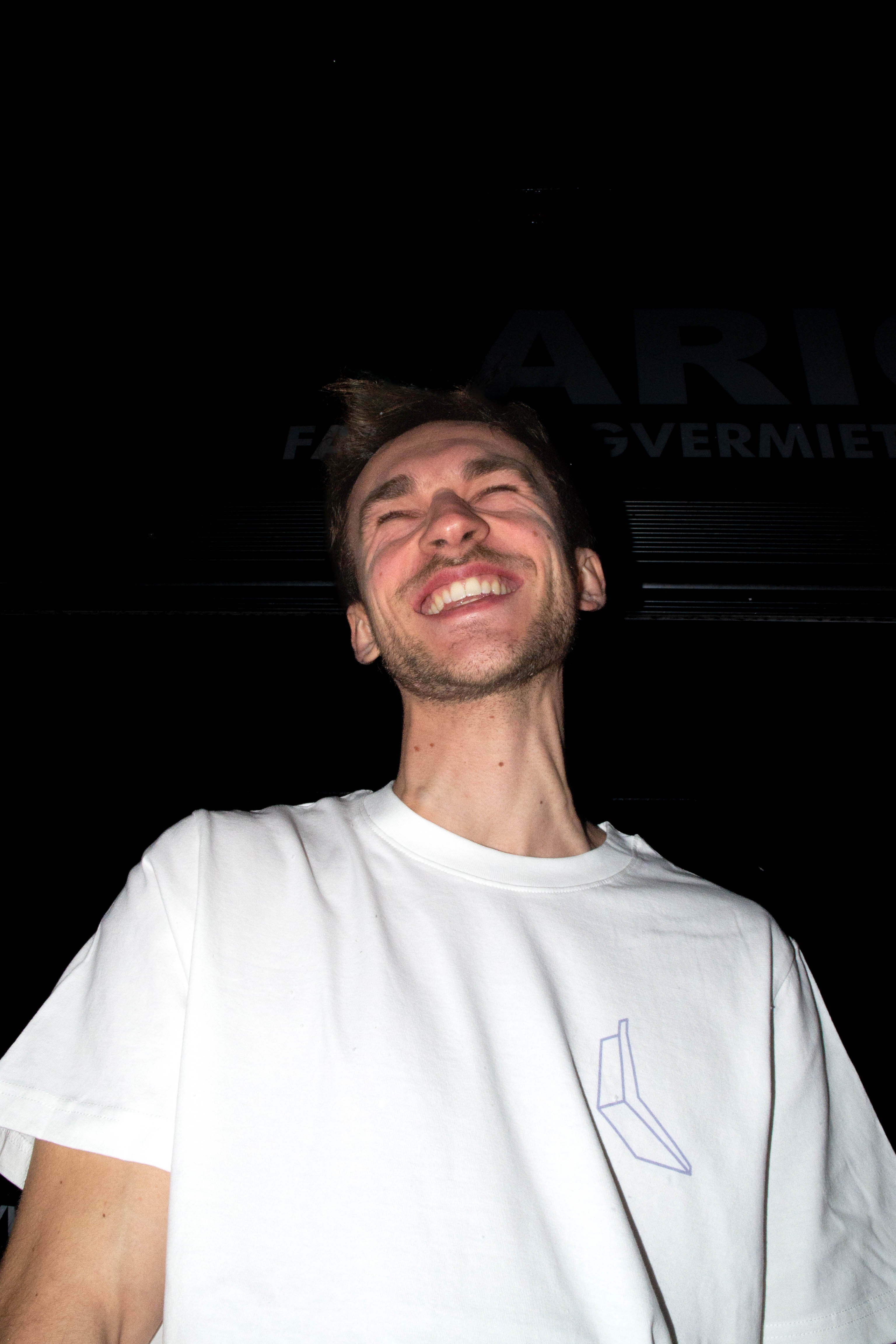 Leon Scholl trägt dsa Banana Climbing Shirt in der Farbe weiß. FrontPrint das Logo von Banana Climbing auf der Linken Brust. Farbe Lila