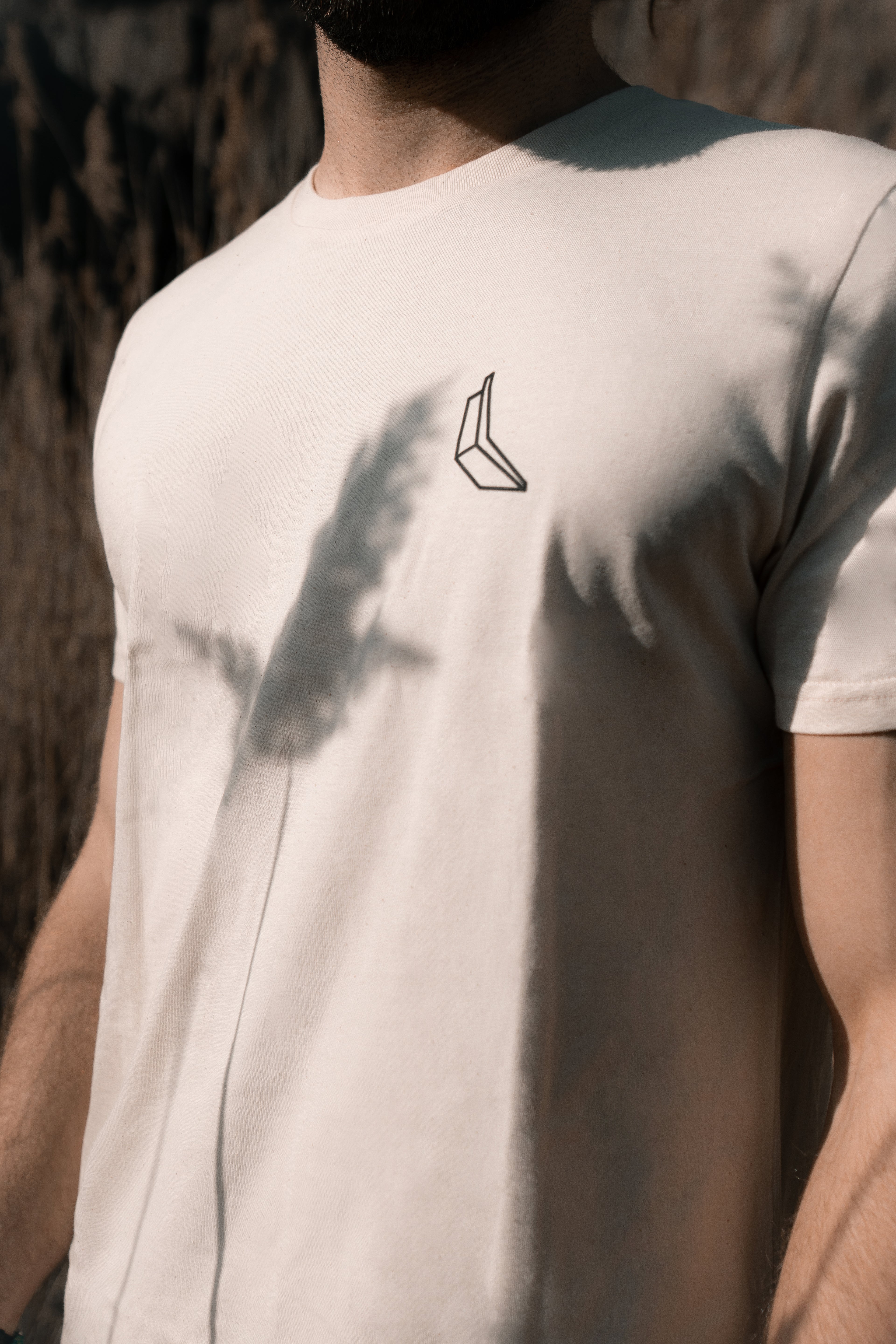 Man sieht den Oberkörper eines Mannes, er trägt ein weißes Banana Volumes T-shirt.