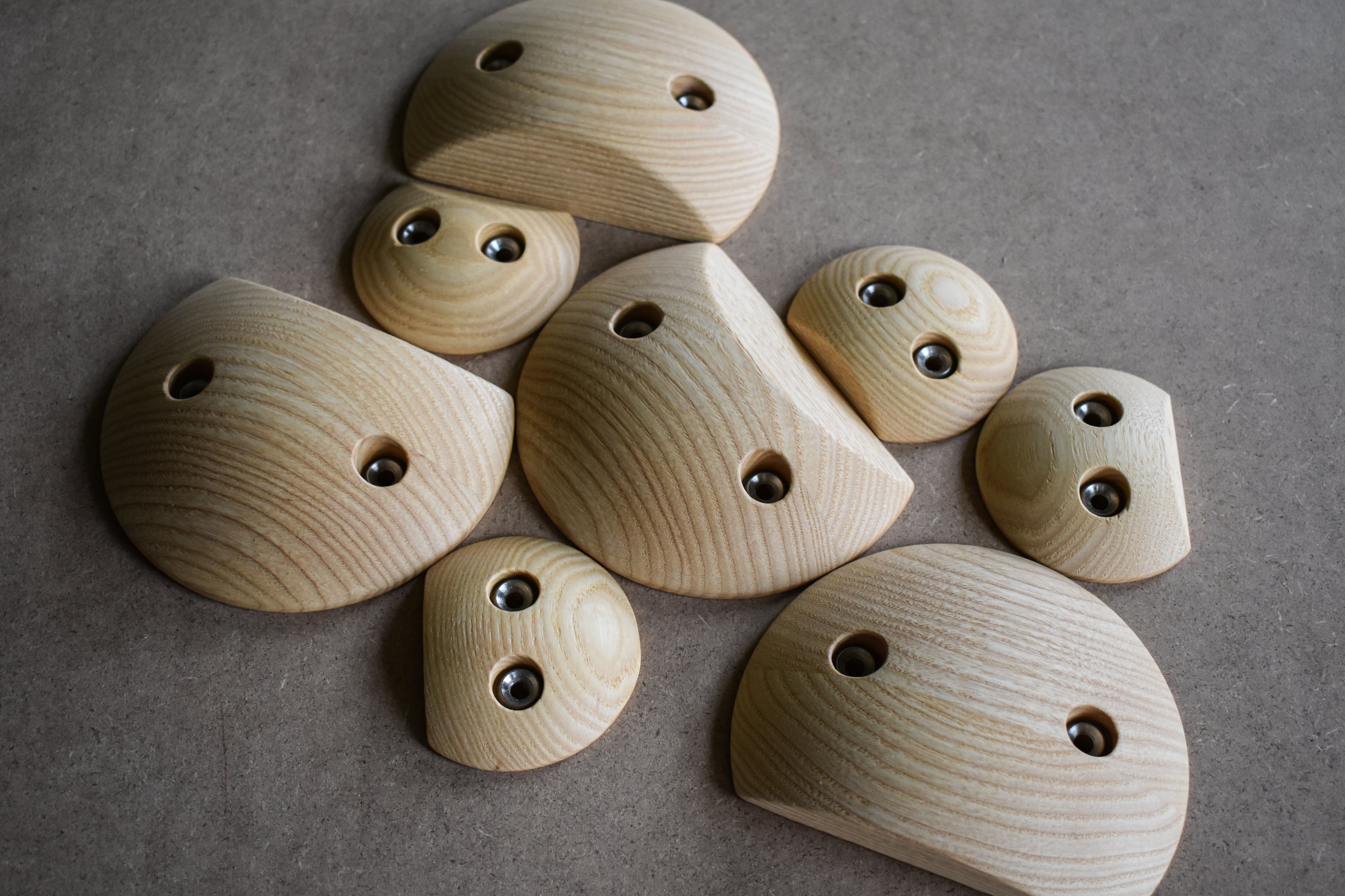 Acht Holztritte mit unterschiedlicher Trittflächenneigung in zwei verschiedenen Größen.