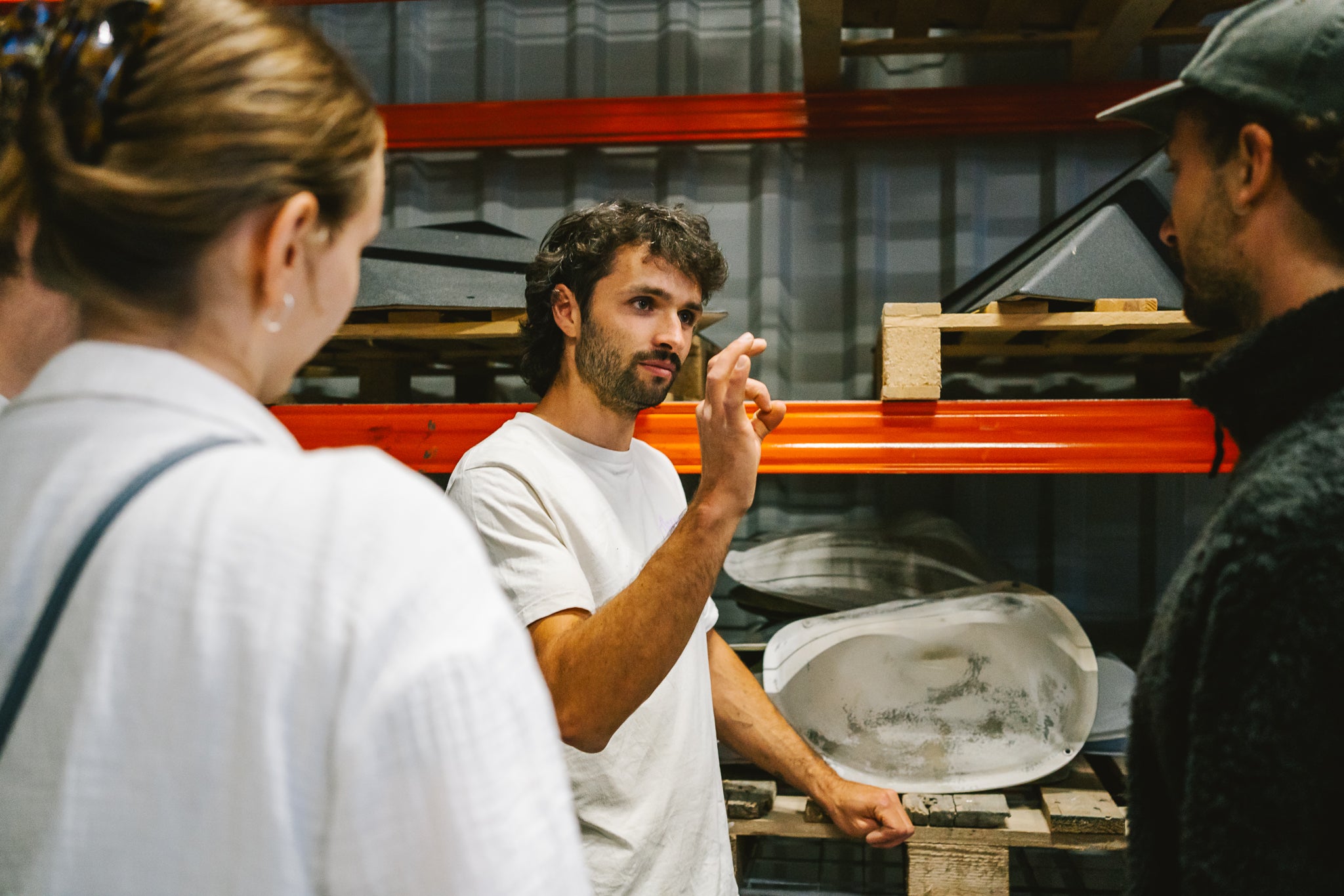Vier Personen unterhalten sich vor einem Regal voller Volumen und GFK Griffen.