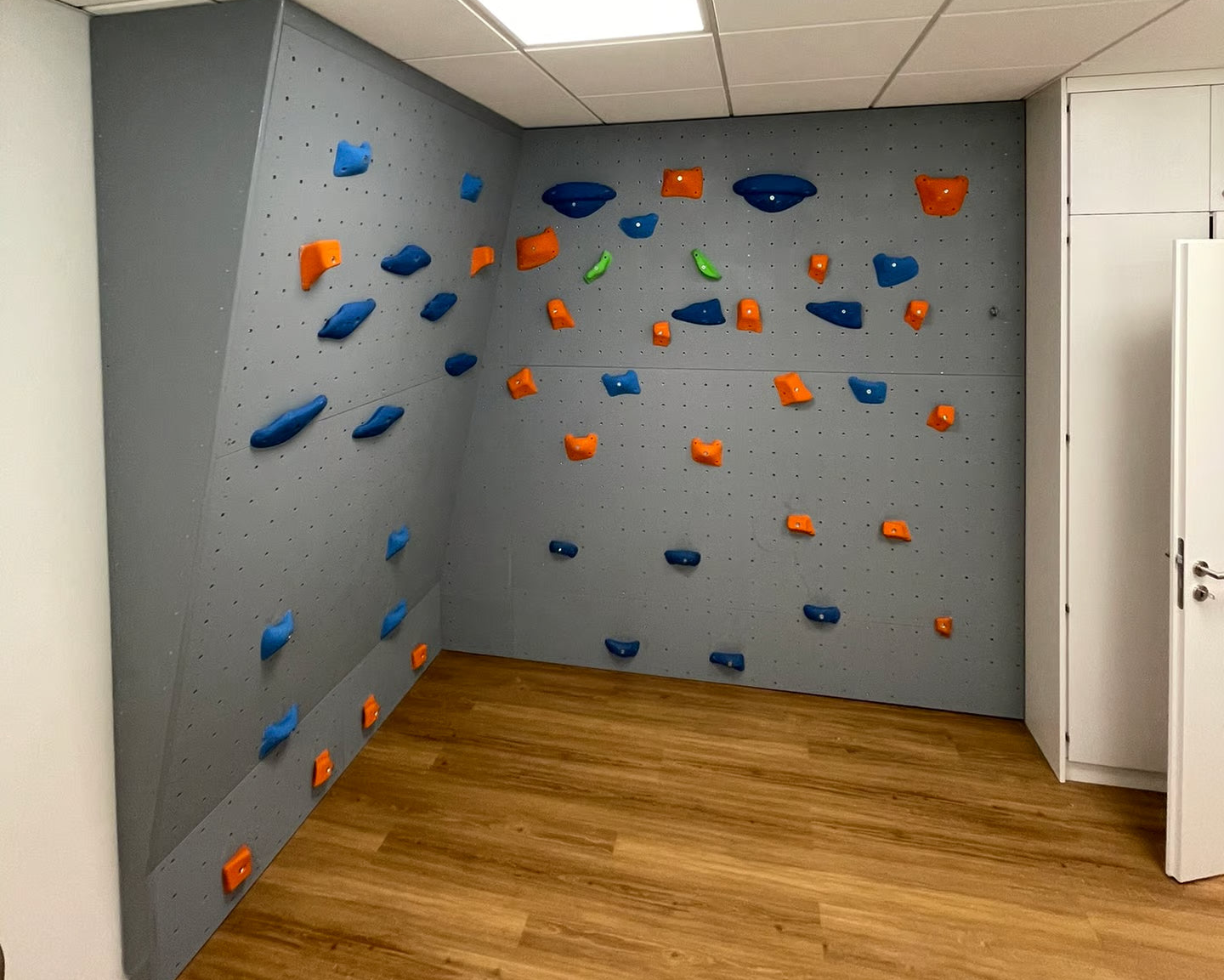 Kletterwand bei Physiotherapeut. Graue Kletterwand, Klettergriffe, Gebaut und beschichtet von Banana Climbing